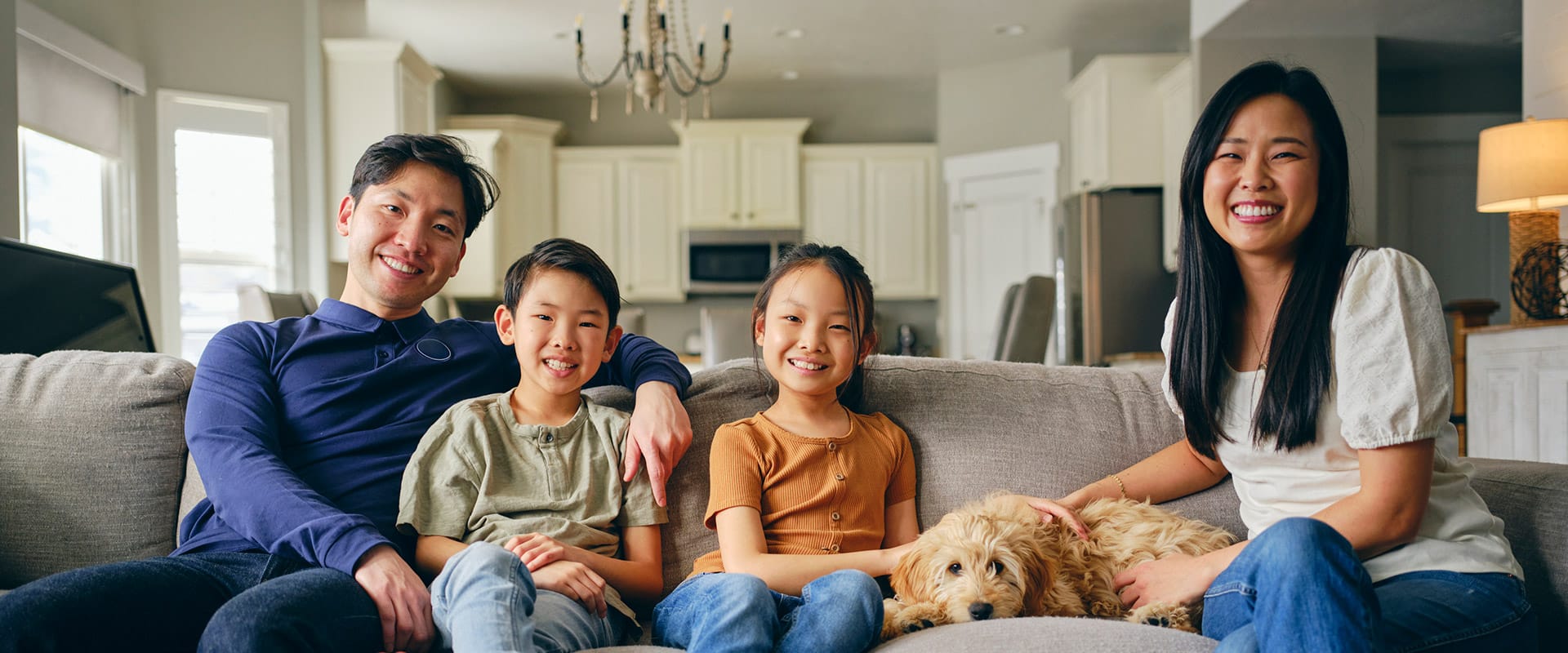 Family smiling together on the couch after orthodontic treatment